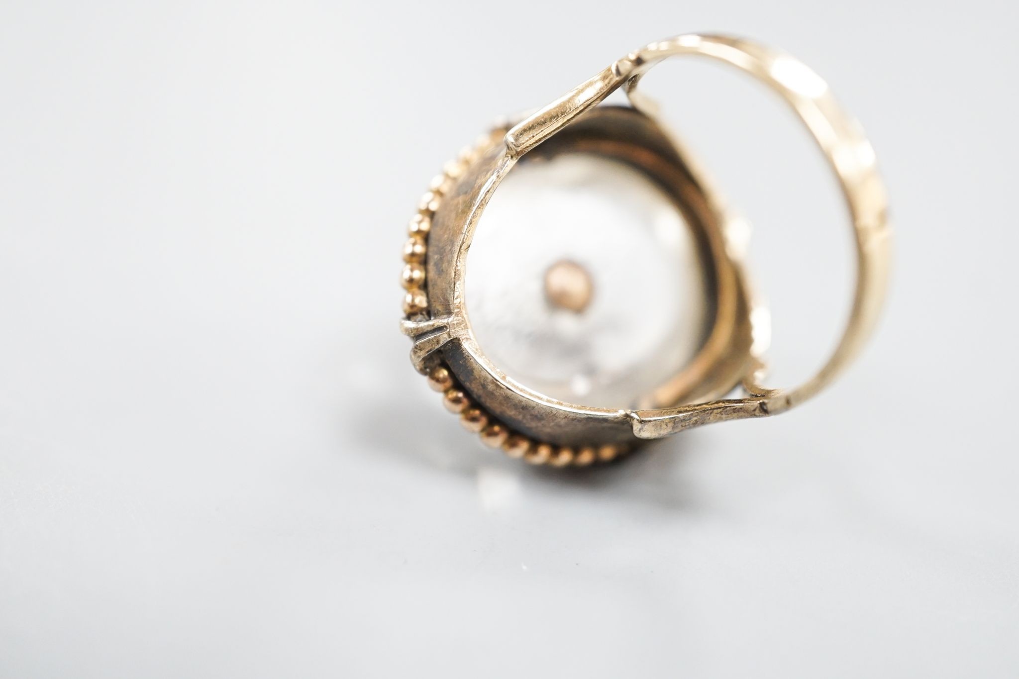 A Victorian, yellow metal and cabochon rock crystal? set dress ring, with central gem set bug motif, size R/S, gross weight 12.4 grams.